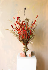 Burnt orange dried flower bouquet in stylish wild arrangements. Strong colours and styles with grasses, poppyseed and statice.